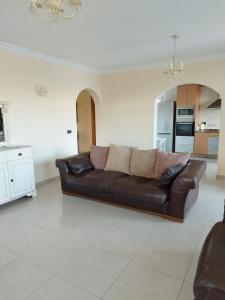 a brown leather couch sitting in a living room at Villa Casa Del Sol 3 Bedroom Villa With Private Solar Covered 12m x 6m Pool Minimum Stay 7 Nights Chromecast And WiFi Throughout The Property in Triquivijate