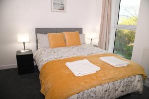 a bedroom with a bed with towels on it at Crayford, Super Cosy 2-Bed Apartment in Dartford