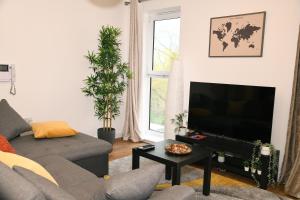 a living room with a couch and a flat screen tv at Crayford, Super Cosy 2-Bed Apartment in Dartford