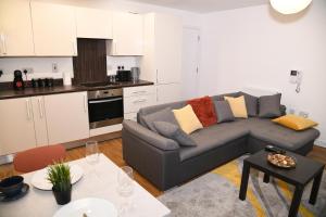 a living room with a couch and a kitchen at Crayford, Super Cosy 2-Bed Apartment in Dartford