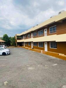 a building with a car parked in a parking lot at Blissett Apt, Your Jamaican Home in Kingston