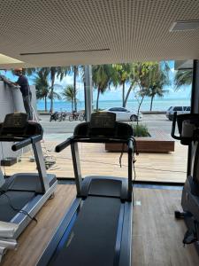 a gym with two cardio machines and a view of the ocean at Unity - Cabo Branco by Jess in João Pessoa
