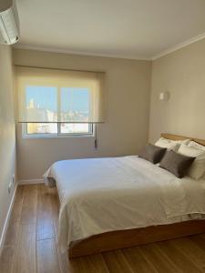 a bedroom with a large bed and a window at Ocean Breeze in Armação de Pêra