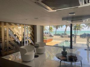uma sala de estar com mesa e cadeiras e o oceano em Unity - Cabo Branco by Jess em João Pessoa