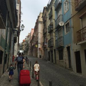 un hombre y una mujer caminando por una calle con equipaje en Apartamento Bairro Alto, en Lisboa