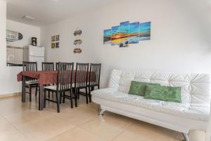 a living room with a couch and a table with chairs at Linda casa a 150m da praia e prox ao Beto Carrero in Penha