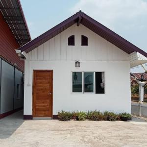 a white house with a brown door on it at บ้านอยู่สบาย บึงโขงหลง in Ban Don Klang