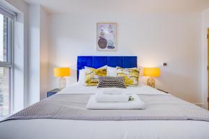 a bedroom with a large white bed with two lamps at Luxe Apartment by Excel in London