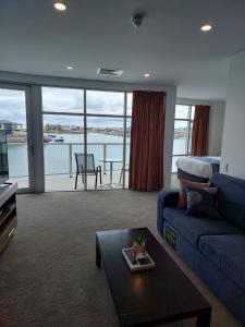 a living room with a blue couch and a table at Wallaroo Marina Executive Apartments in Wallaroo