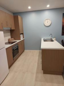 a kitchen with a sink and a clock on the wall at Wallaroo Marina Executive Apartments in Wallaroo