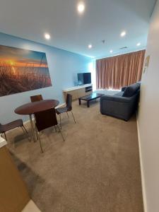 a living room with a couch and a table and chairs at Wallaroo Marina Executive Apartments in Wallaroo