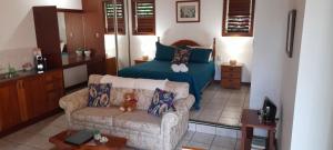 a living room with a couch and a bed at Eden House Retreat in Yungaburra