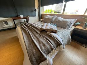Una cama con una manta y botellas de agua. en The UpperRoom @ Real Suites en Bacolod