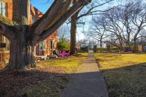 a sidewalk in front of a house with a tree at Franklin Park 3BR Condo near Airport, Downtown, OSU in Columbus
