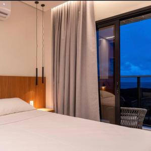 a bedroom with a bed and a large window at Salinas Premium Resort Apto completo in Salinópolis