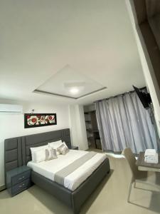 Schlafzimmer mit einem Bett und einem Schreibtisch mit einem Telefon in der Unterkunft Hotel Don Felipe in Ríohacha