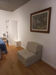 a bedroom with a couch and a painting on the wall at Grace210 in Buenos Aires