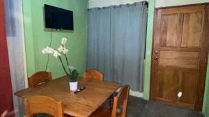 Una mesa de comedor con un jarrón de flores encima. en Casa Rural Aralia, en Fortuna