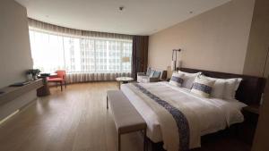 a hotel room with a large bed and a large window at LIUZHOU PENGYI Hotel in Liuzhou