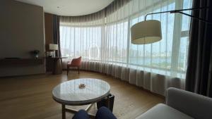 a living room with a table and a large window at SHENZHENAIR SKY PARK LIUZHOU in Liuzhou