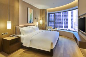 a bedroom with a large white bed and a large window at SHENZHENAIR SKY PARK LIUZHOU in Liuzhou