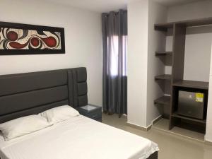 1 dormitorio con 1 cama y TV en Hotel Don Felipe, en Ríohacha