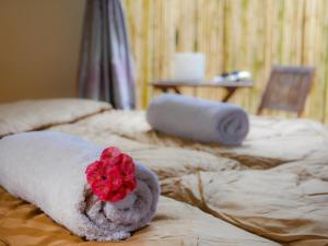 two beds with towels and a red flower on them at Arcadia Downtown Backpackers in Kampot