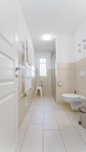 La salle de bains blanche est pourvue d'une baignoire et d'un lavabo. dans l'établissement Käpt'n Kalle Ferienwohnungen, à Zingst