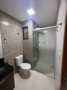 y baño con aseo y ducha acristalada. en Excelente Apartamento mobiliado em Campina Grande, en Campina Grande