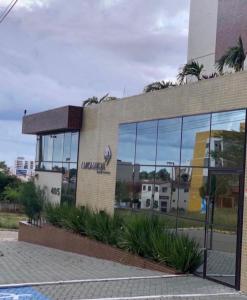 un edificio con muchas ventanas y palmeras en Excelente Apartamento mobiliado em Campina Grande, en Campina Grande