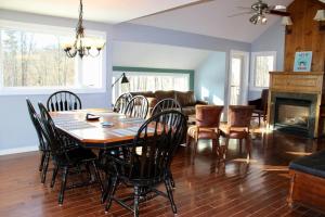 a dining room and living room with a table and chairs at Condo 4 with AC Sauna and Hot tub Slopeside in the Winter in Killington