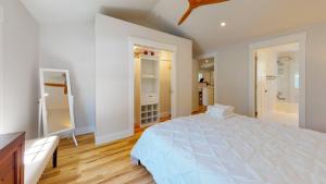 a large white bedroom with a large bed and wooden floors at Modern 2BR 2BA with King bed-Fast Wi-Fi 75 inch OLED TV in Wilmington