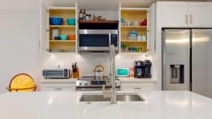 a white kitchen with a sink and a refrigerator at Modern 2BR 2BA with King bed-Fast Wi-Fi 75 inch OLED TV in Wilmington +13 photos
