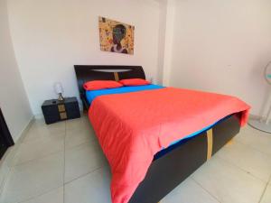 een slaapkamer met een bed met een rood en blauw dekbed bij RODADERO LONDON 1003 in Rodadero