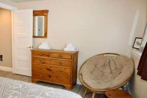 une chambre avec une commode, une chaise et un miroir dans l'établissement Condo #5 Slopeside One Bedroom with Sauna and Hot tub, à Killington