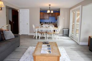 un salon avec un canapé, une table et des chaises dans l'établissement Condo #5 Slopeside One Bedroom with Sauna and Hot tub, à Killington