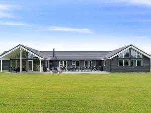 a black house with a large yard in front of it at Luxury Pool Villa in Grena - By Traum Ferienwohnungen in Grenå