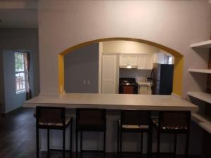 - une cuisine avec un comptoir et des tabourets dans une pièce dans l'établissement Casa la CEIBA, à Tancama