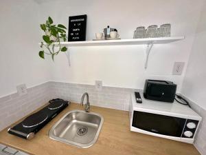 a kitchen with a sink and a microwave at Beach guests house in Miami