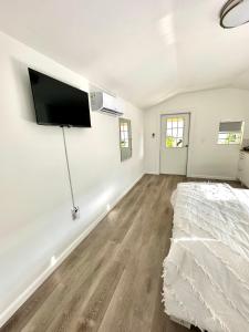 a bedroom with a bed and a flat screen tv on the wall at Beach guests house in Miami