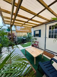 a patio with a wooden pergola and a wooden table at Beach guests house in Miami