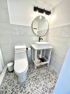 a bathroom with a toilet and a sink and a mirror at Beach guests house in Miami