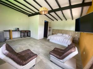 ein Wohnzimmer mit Sofas und einem Flachbild-TV in der Unterkunft Cabañas Campestres MaRGuin in Paipa