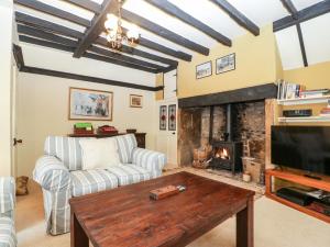 a living room with a couch and a fireplace at Red Roof in Honiton