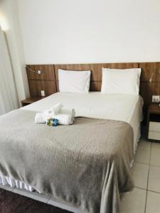 a bedroom with a bed with two stuffed animals on it at Apart-Hotel Premium in Brasilia +13 photos
