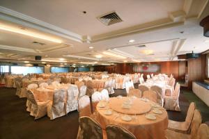 un salón de banquetes lleno de mesas y sillas con ropa de cama blanca en APAC Lukang Resort, en Lukang