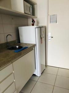 a kitchen with a white refrigerator and a sink at Apart-Hotel Premium in Brasilia