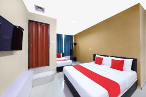 a hotel room with two beds and a flat screen tv at Hotel Inap in Batu Caves