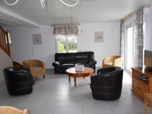 a living room with black leather furniture and a coffee table at Gîte spacieux avec terrain clos, terrasse, 4 chambres, animaux acceptés, près de Belle-et-Houllefort - FR-1-376-104 in Belle-et-Houllefort