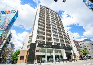 un edificio blanco alto con un letrero. en APA Hotel Midosuji-Honmachi-Ekimae, en Osaka